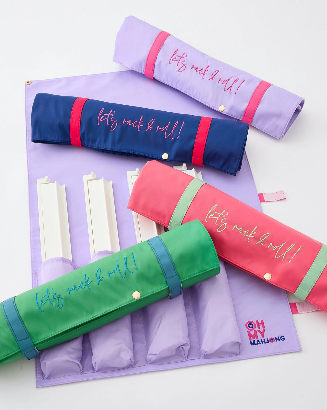 Colorful carrying cases for a set of Mahjong racks & pushers on a white background
