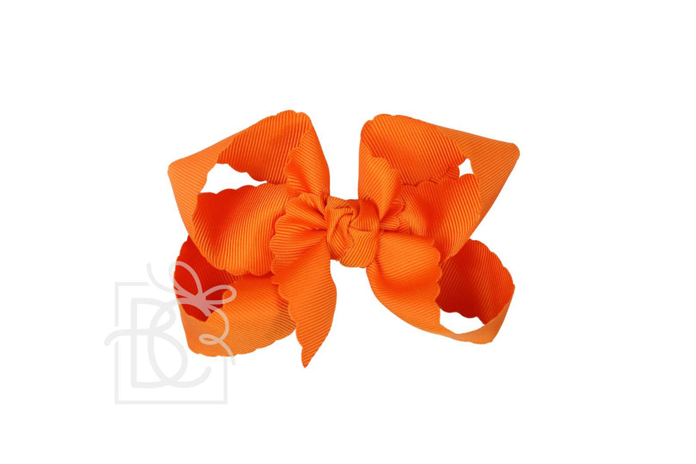 A bright orange scalloped edge hair bow