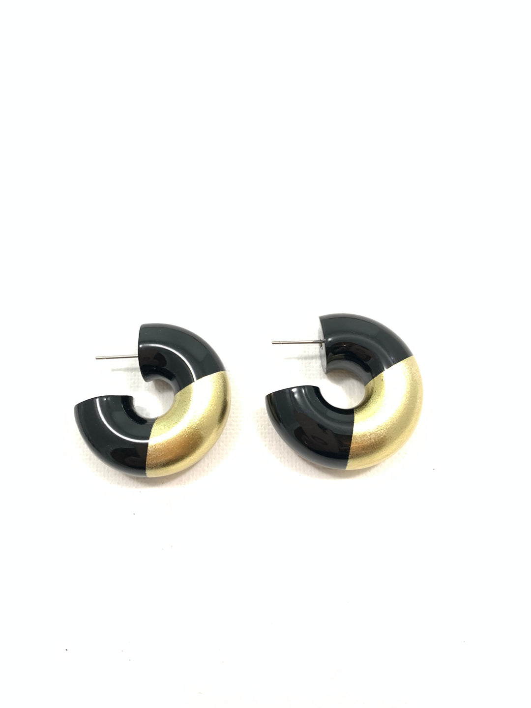 A pair of modern geometric hoop earrings with a black and gold color-blocked design, displayed on a clean white background.