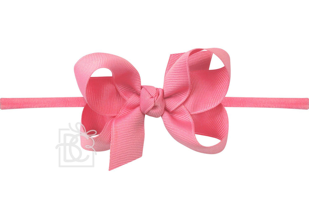 A hot pink bow headband on a white background
