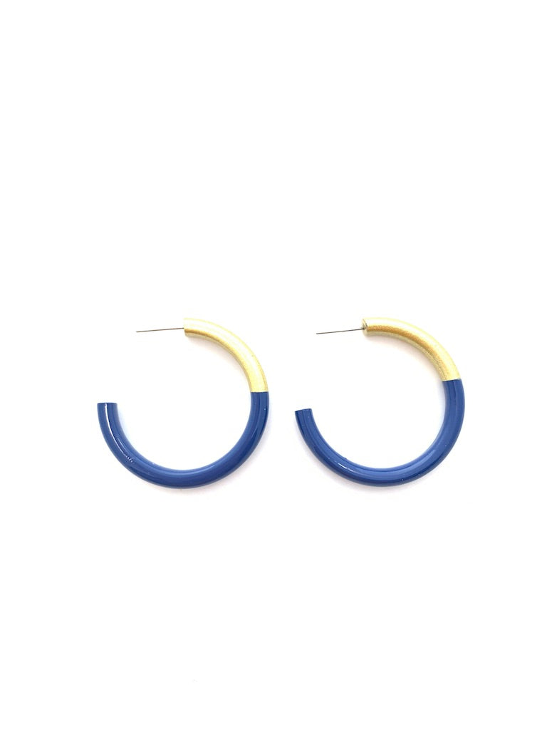 A pair of half-hoop earrings with a navy blue lower half and a gold upper half, shown on a plain white background.