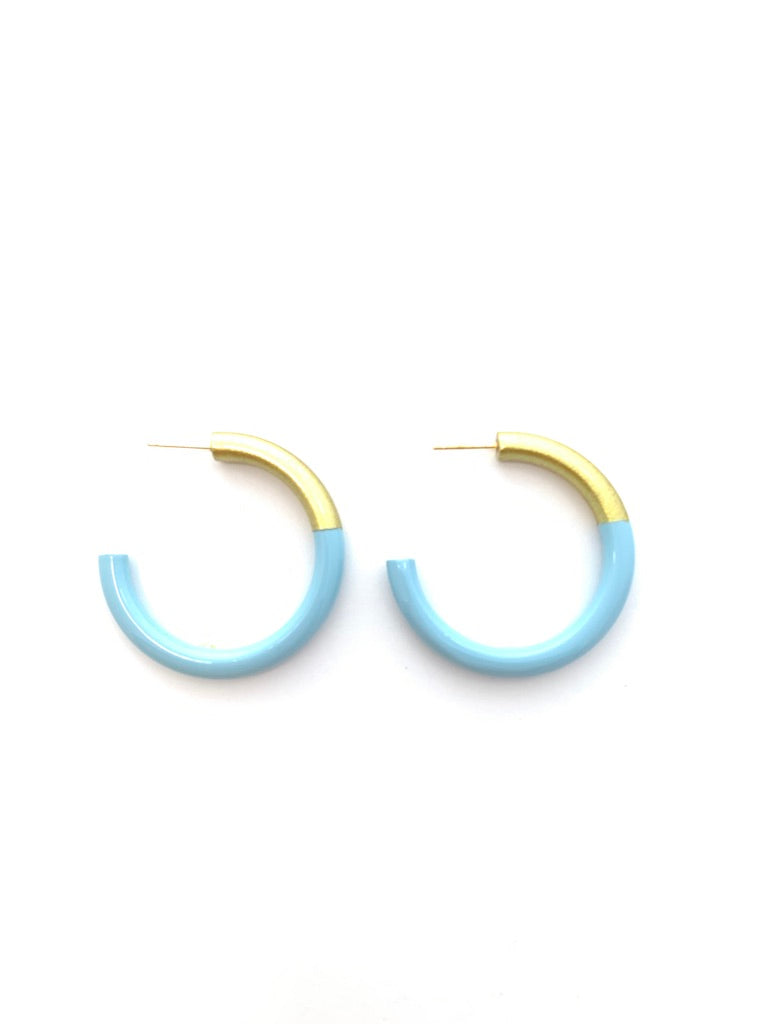 A pair of light blue hoop earrings with a gold-colored inner band, displayed on a clean white background.