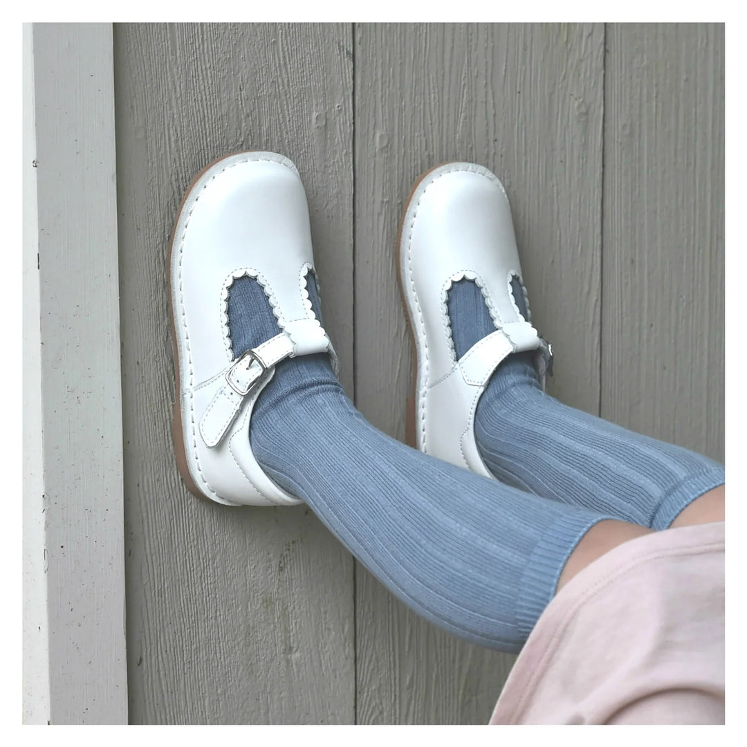 White shoes with blue socks on a wooden floor