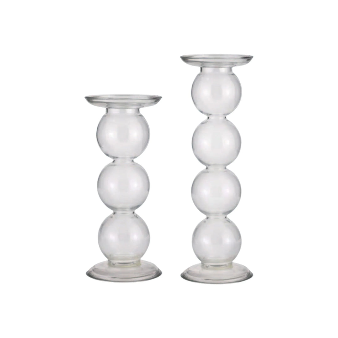 Two clear glass candle holders with spherical design on a white background