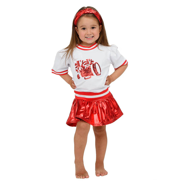 Young girl wearing a red and white outfit with a skirt, standing on a white background.