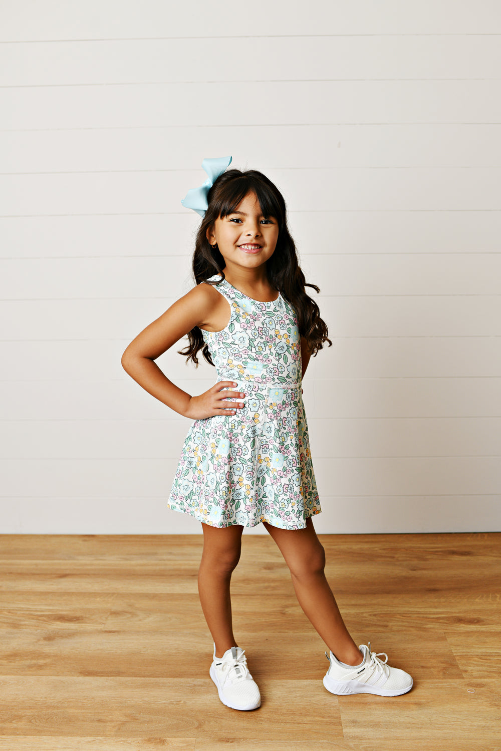 FLORAL PRINT WITH AQUA DETAIL SLEEVELESS WITH CRISSCROSS BACK STYLED ON LITTLE GIRL WITH BROWN HAIR