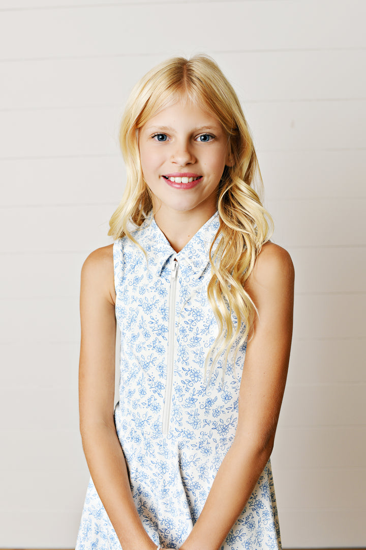 Young girl wearing a floral dress against a plain background
