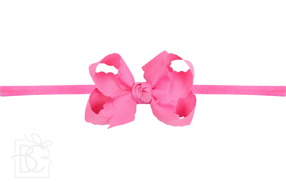 A hot pink scalloped edge pantyhose headband with a bow.