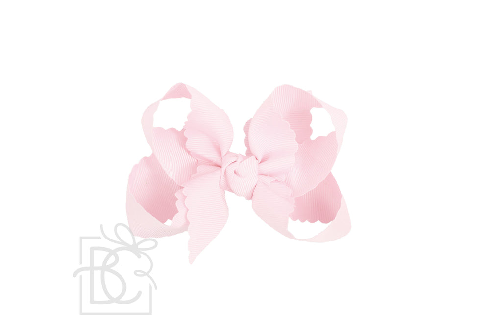 A scalloped edge bow in pink color