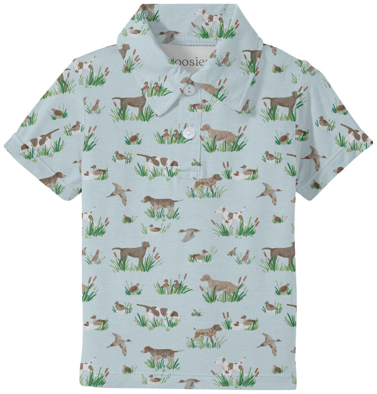 Children's polo shirt with dog pattern on a light blue background