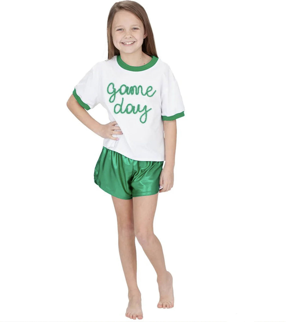 Child wearing a 'game day' outfit with a white shirt and green shorts on a white background.