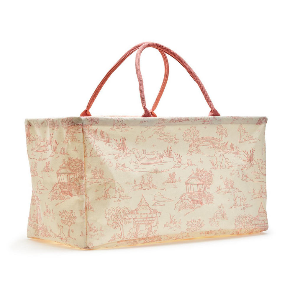 Two toile hamper bags in beige and blue colors with animal patterns and sturdy handles.