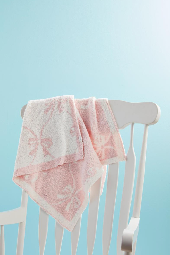 pink chenille blanket hanging over chair