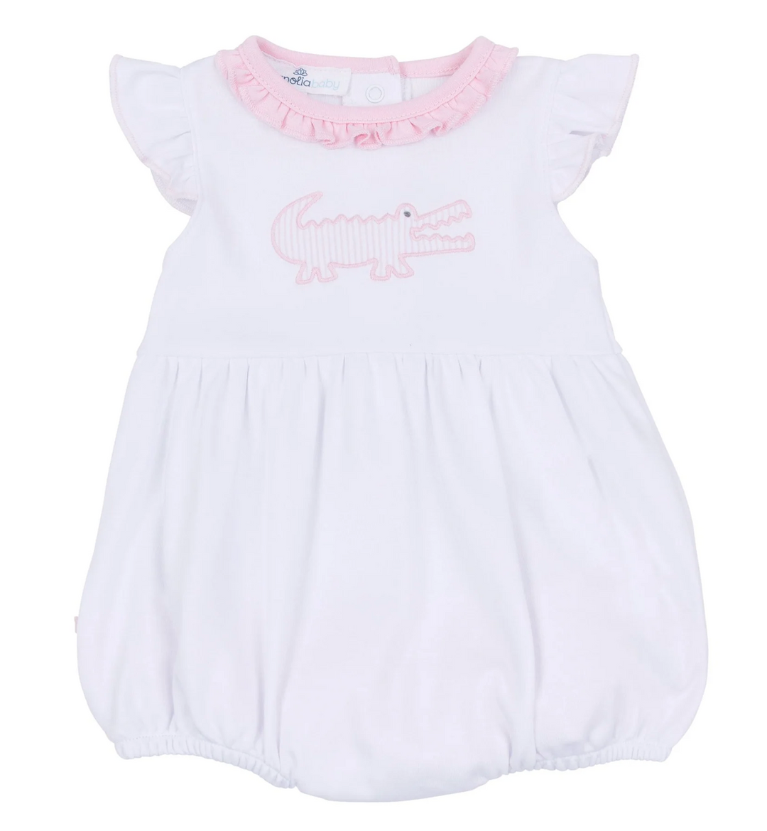 White baby romper with pink accents and a crocodile design on a white background