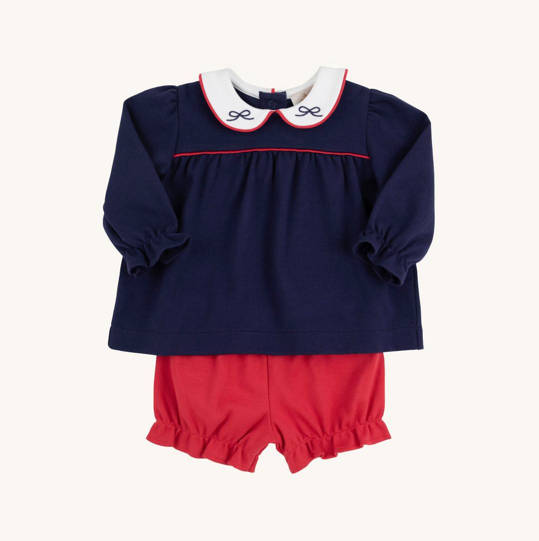 Navy blue top with white collar and red trim, paired with red shorts on a white background