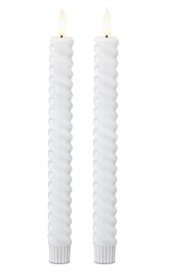 Two white twisted candles on a white background
