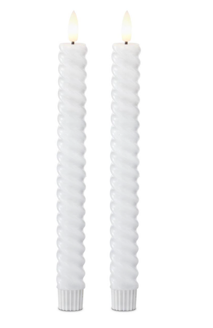 Two white twisted candles on a white background