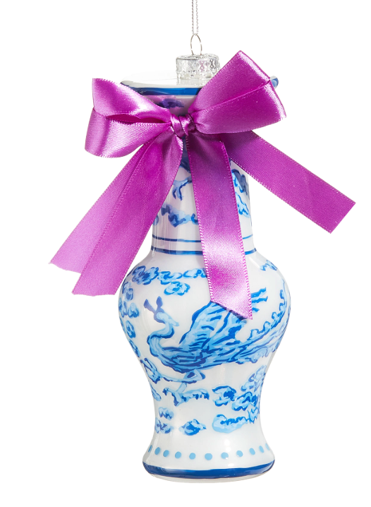 Decorative vase ornament with blue patterns and a purple bow on a white background