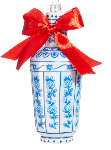 Decorative vase with blue floral patterns and a red bow on a white background