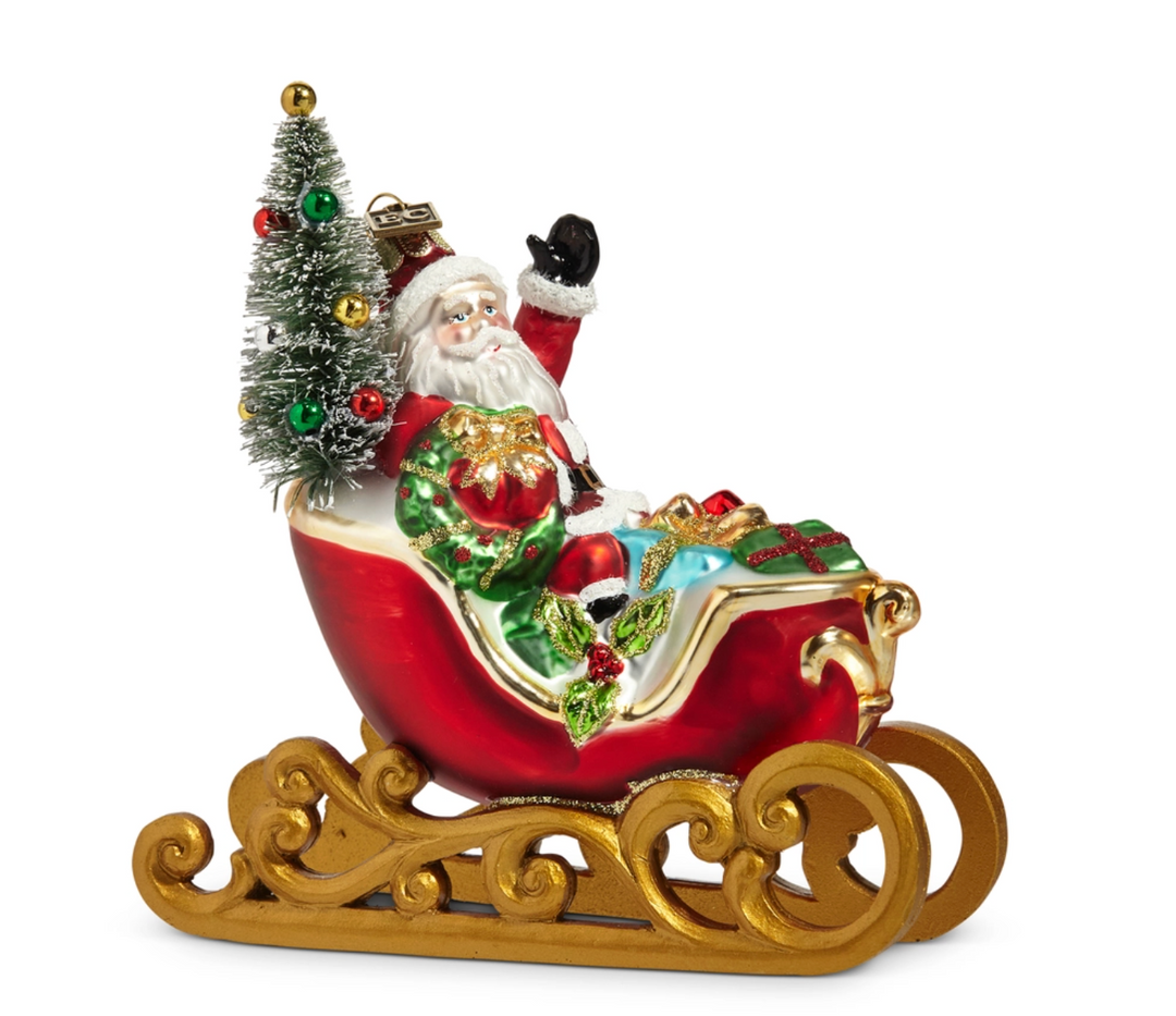 Decorative figurine of Santa Claus in a sleigh with a small Christmas tree on a white background