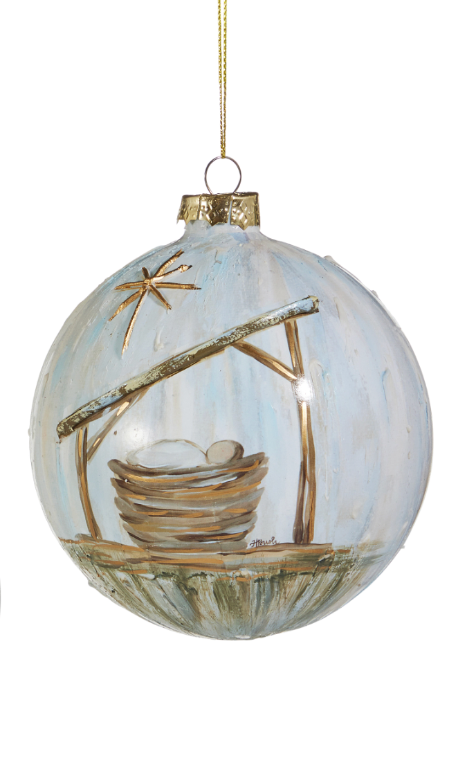 Decorative glass ball with a bird's nest and eggs on a branch inside, hanging against a white background.