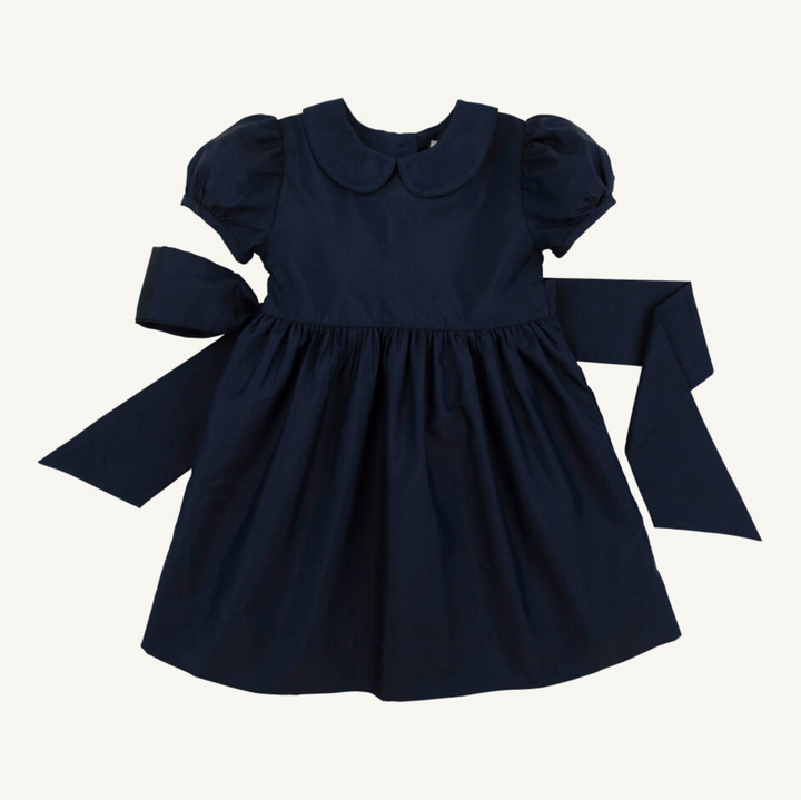 Navy blue dress with puffed sleeves and a large bow on a white background