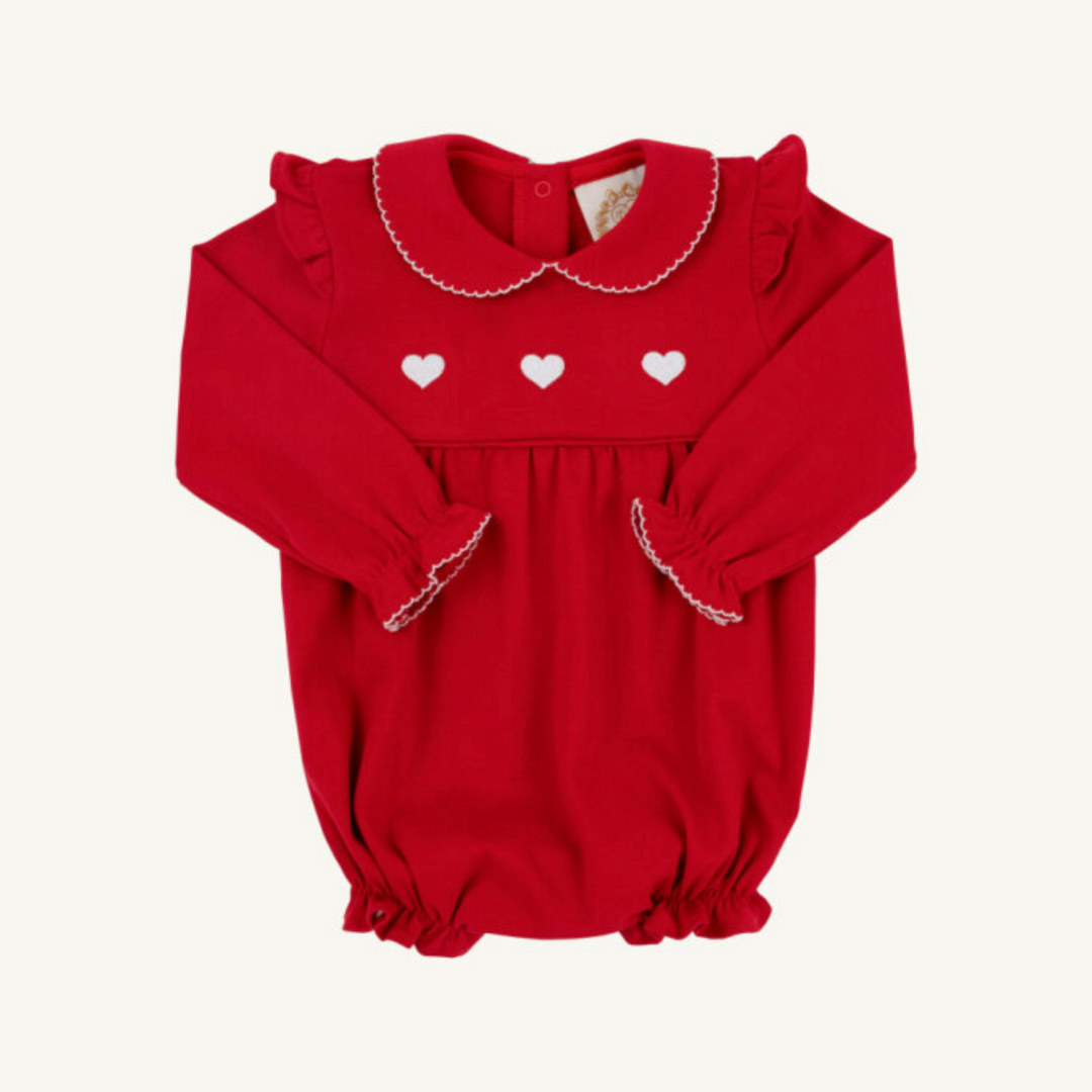 Red baby romper with white heart designs on a white background