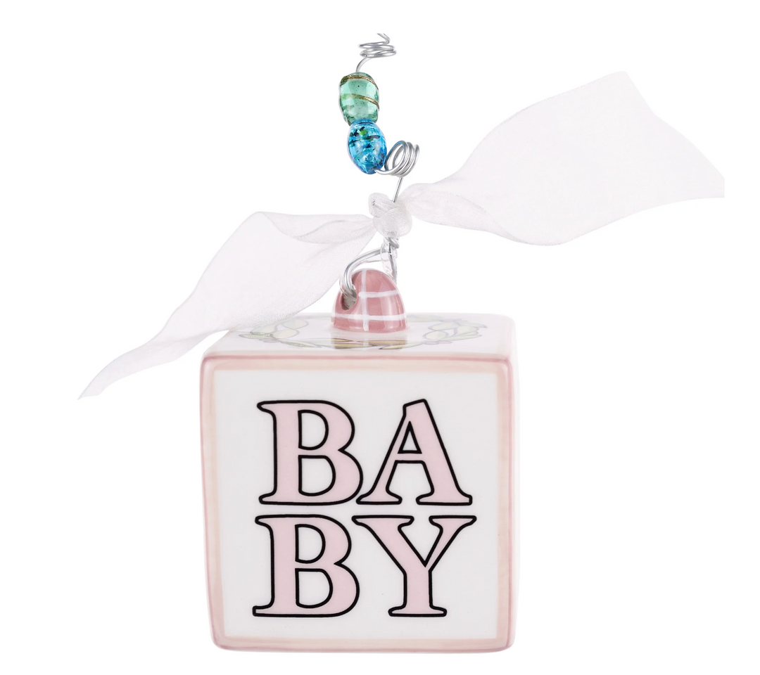 Decorative cube with 'BABY' text and beads on a white background
