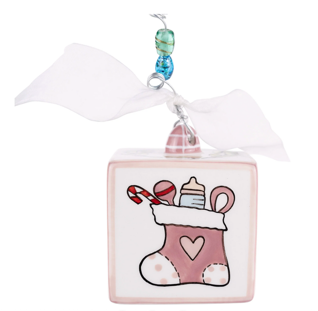 Decorative Christmas ornament with a pink stocking and candy design on a white background