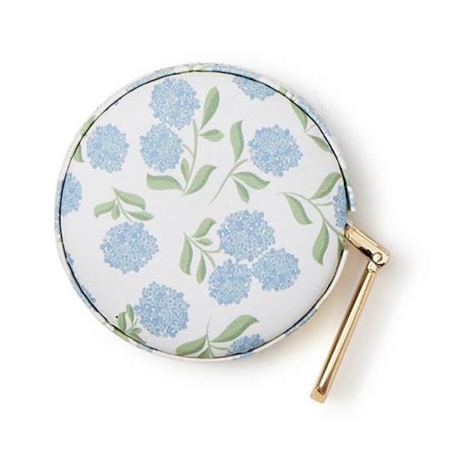 Round pouch with floral design and gold clasp on a white background