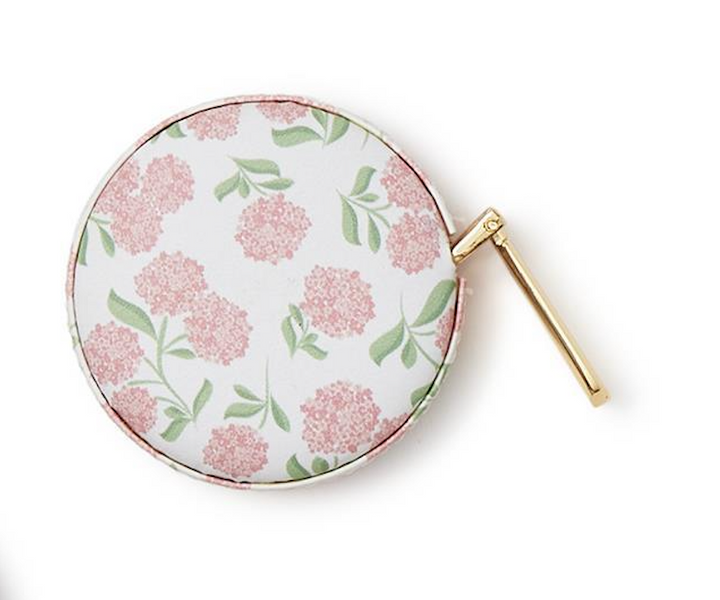 Round floral-patterned compact mirror with a gold handle on a white background