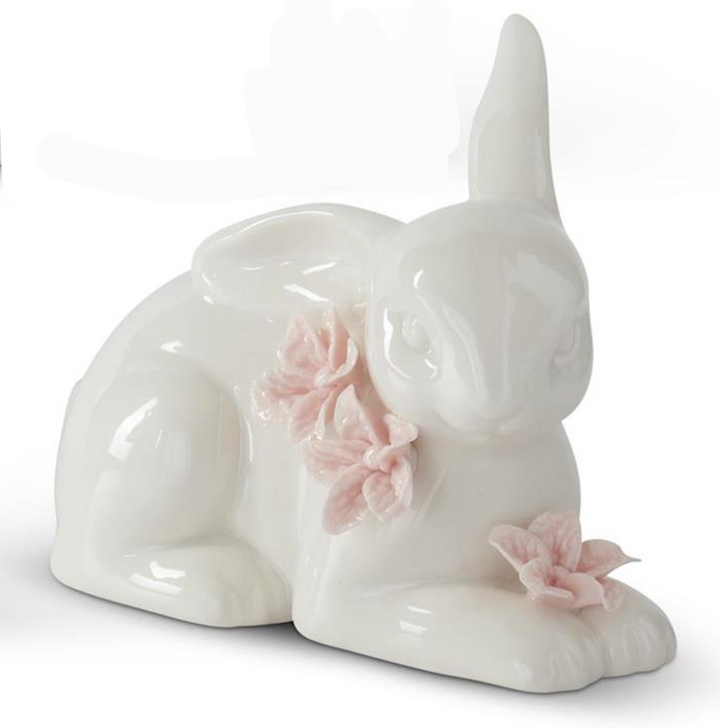 White ceramic dog figurine with pink flowers on a white background