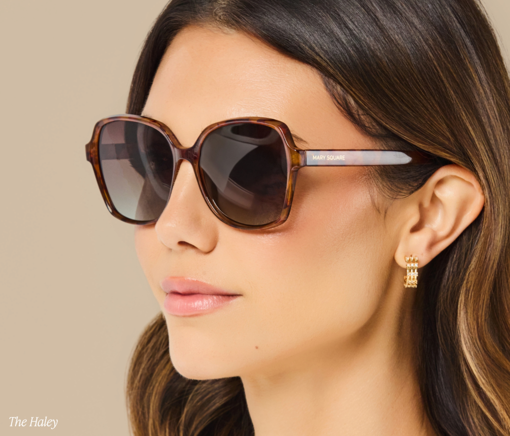 A close-up side profile of a woman wearing oversized square sunglasses with tortoiseshell frames and dark lenses. The brand name 'PAUL JOHNSON' is visible on the temple arm.