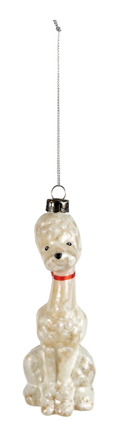 A vintage-style poodle ornament in a glossy, pearlescent off-white glass with a small red collar, hanging from a silver metal chain against a plain white background.