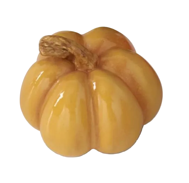 A glossy ceramic decorative pumpkin figurine in a warm golden-orange color with a brown stem, shown on a white background.