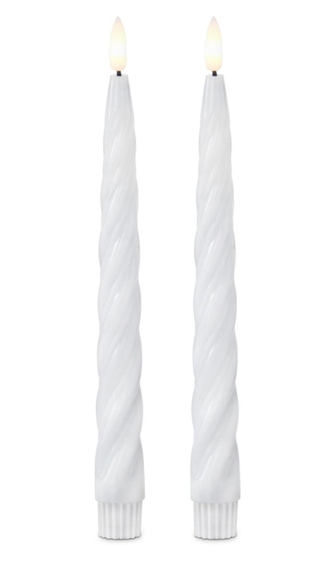 Two white twisted candles on a white background