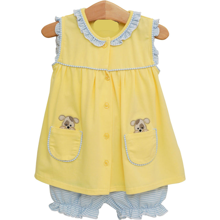 Yellow dress with puppy designs on a hanger against a white background with matching bloomers