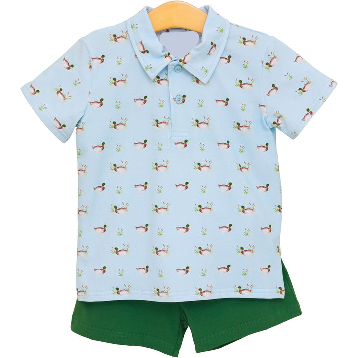 Children's outfit with a light blue polo shirt and green shorts on a white background