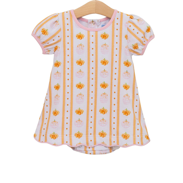 Baby dress with pumpkin pattern on a hanger against a white background