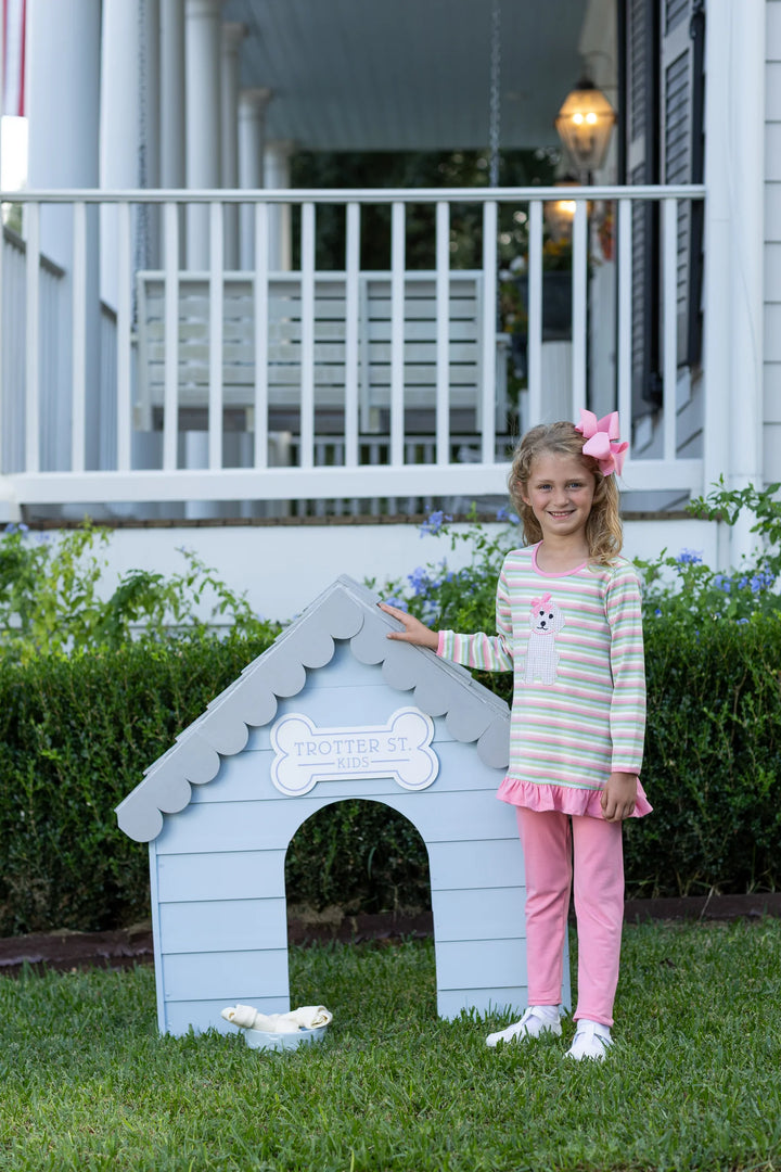 YOUNG GIRL IN PINK COORDINATING LEGGING SET OUTFIT IN FRONT OF BLUE DOG HOUSE
