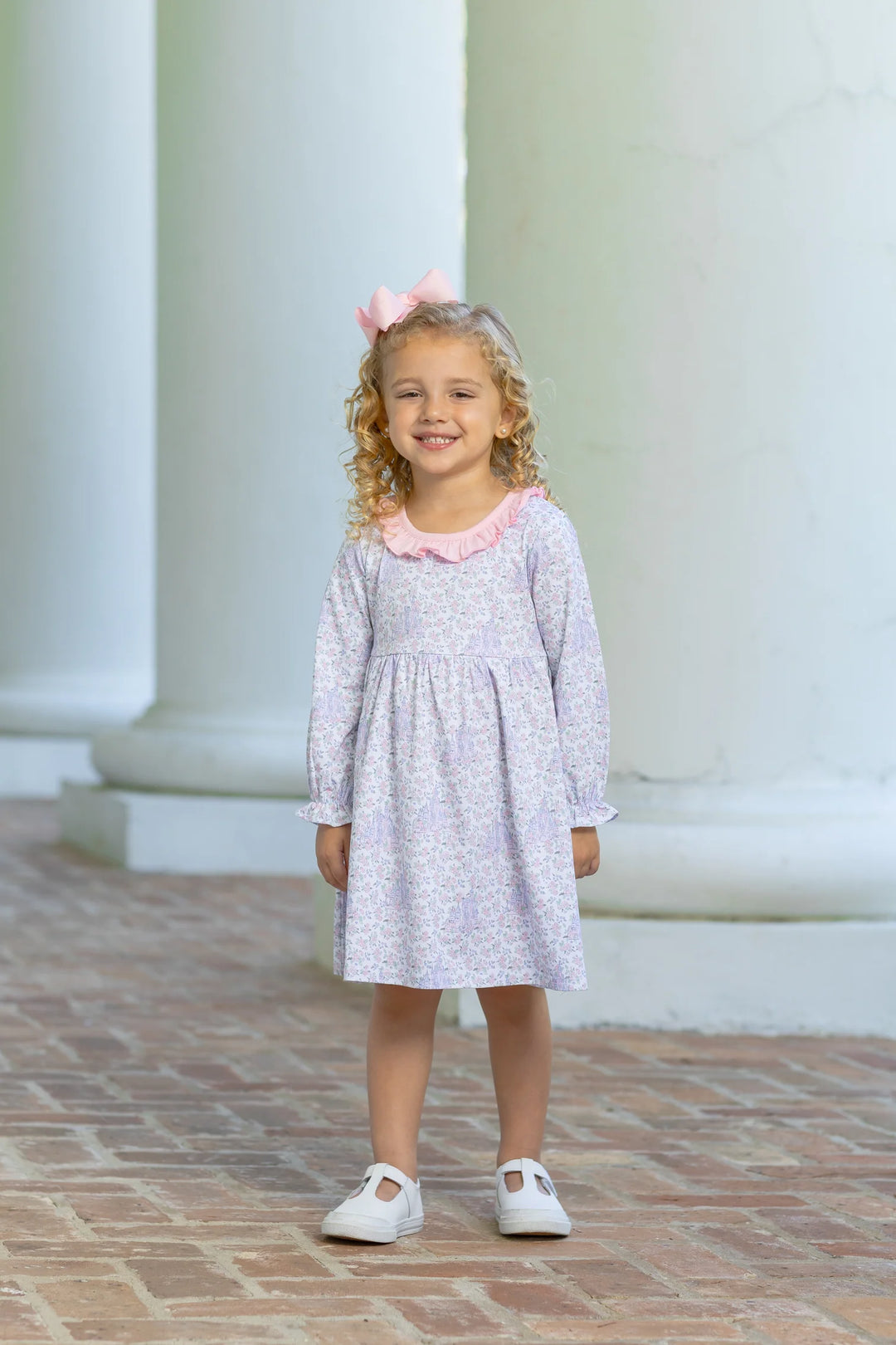 LITTLE GIRL WEARING HIDDEN CASTLE FLORAL DRESS ON BRICK STEPS