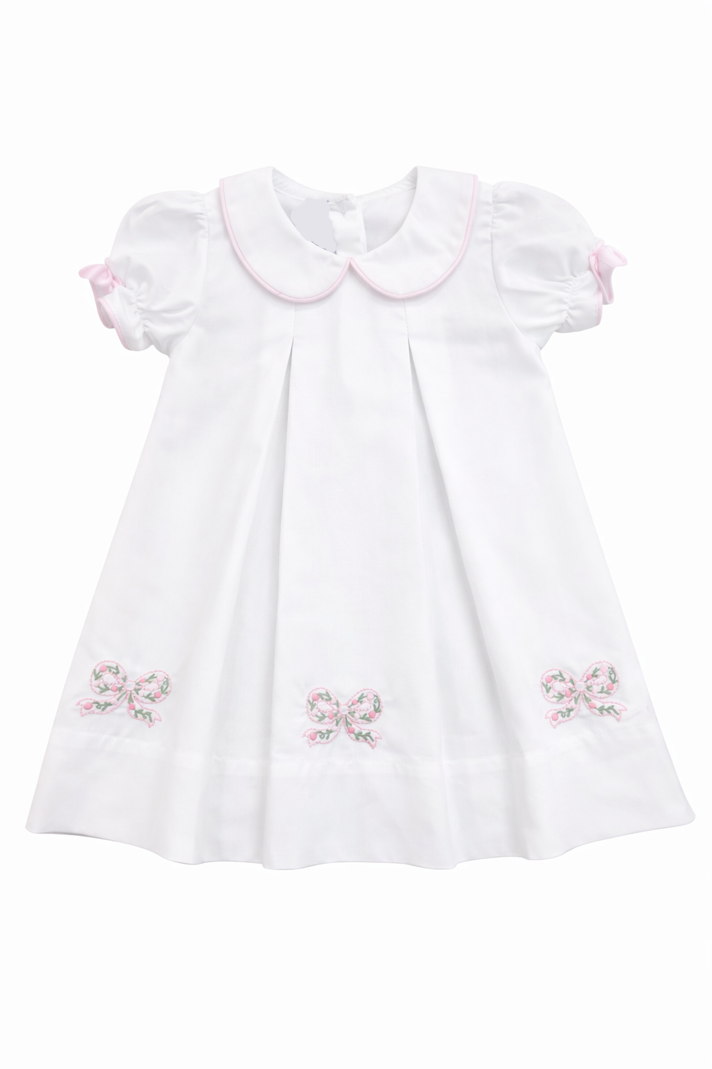 white dress with pleats and 3 applique bows on dress on white background