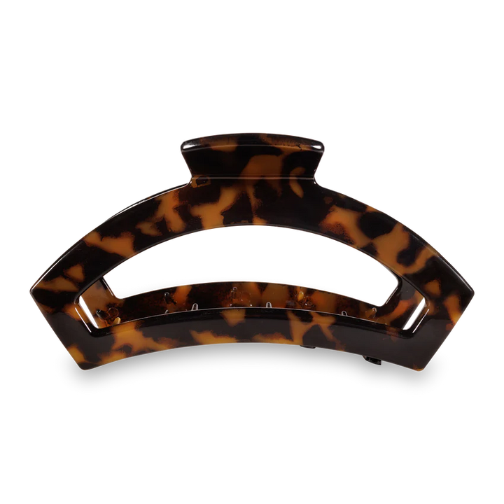 A large hair claw clip in a glossy tortoiseshell pattern, featuring dark brown and amber-brown mottled colors, shown on a clean white background.
