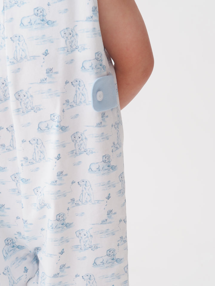 Close-up of a white garment with blue puppy pattern and button detail.