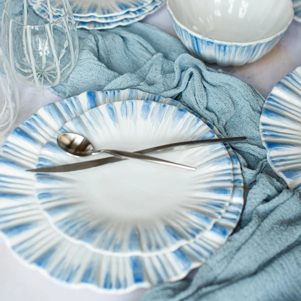 Blue and white ceramic plates with cutlery on a light blue cloth