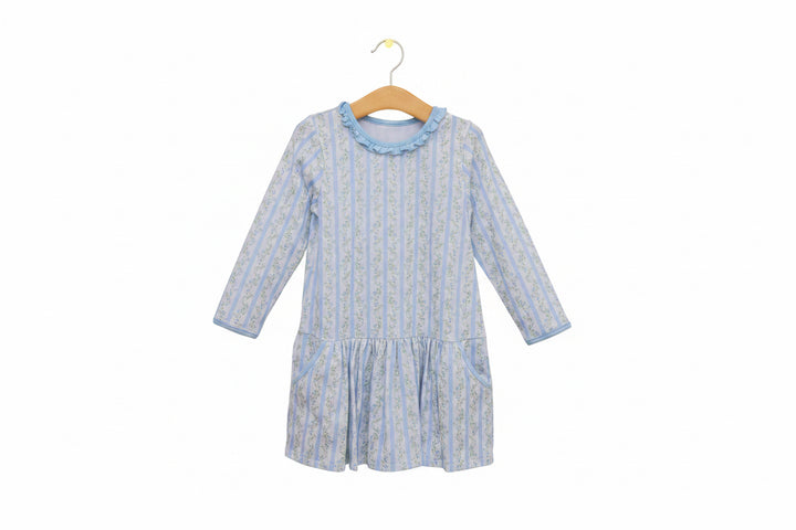 Blue and white patterned dress on a hanger against a white background