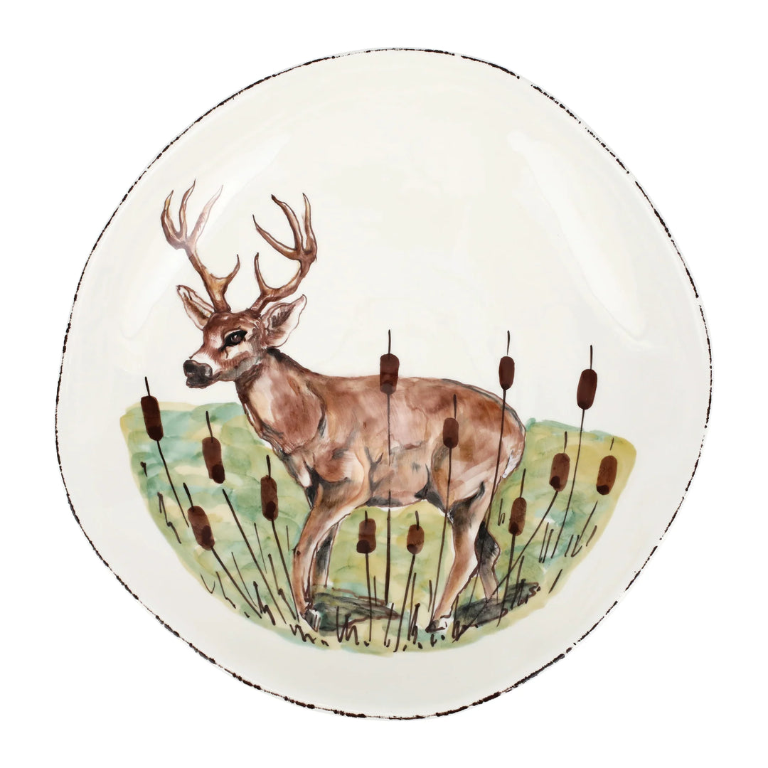 A handpainted ceramic bowl featuring a deer design with tall grass and a clear sky in the background.