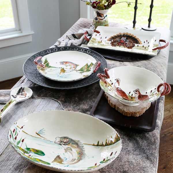 Dining table set with ceramic dishes featuring fish designs, placed on a wooden surface.