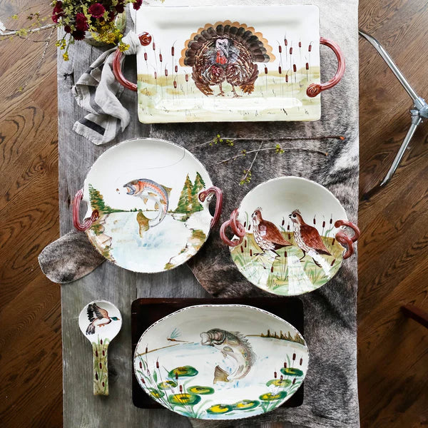 Set of ceramic plates with nature-themed designs on a wooden table.