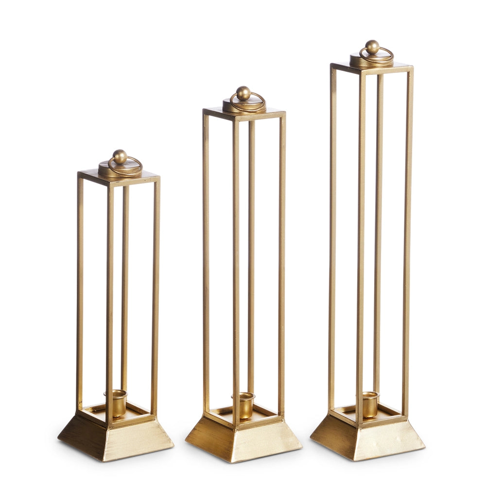 Three gold candle holders of different heights on a white background